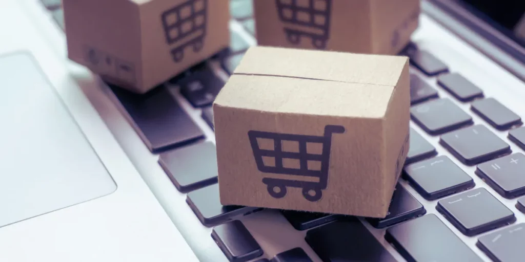woocommerce: 3 błędy, przez które Twoi klienci tracą pieniądze. Grafika przedstawiająca małe kartony z ikoną wózka sklepowego.