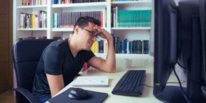 Problemy na stronie wordpress - niezadowolony mężczyzna przed komputerem